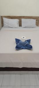 una cama con un rollo de papel higiénico encima en Amed Stop Inn Homestay, Rooftop Restaurant and Bar, en Amed
