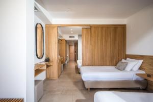 a hotel room with two beds and a mirror at Stella Palace Aqua Park Resort in Hersonissos