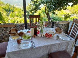 una mesa con un mantel blanco con comida. en Stone House en Këlcyrë