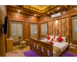 ein Schlafzimmer mit einem Bett in einem Zimmer mit Holzwänden in der Unterkunft Wayanad Fort Resort, Noolpuzha, Kerala in Muthanga