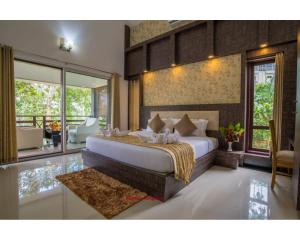 a bedroom with a large bed and a balcony at Wayanad Fort Resort, Noolpuzha, Kerala in Muthanga