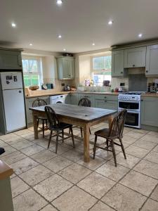a kitchen with a wooden table and chairs at Gurteen farm house in Clonmel