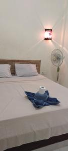 a bed with a towel and a roll of toilet paper on it at Amed Stop Inn Homestay, Rooftop Restaurant and Bar in Amed