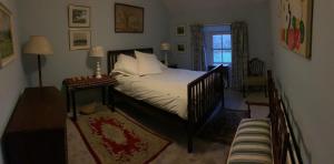 a bedroom with a crib and a bed with a window at Gurteen farm house in Clonmel