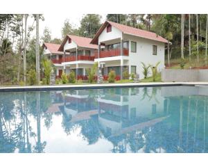 una gran piscina frente a una casa en Wayanad Fort Resort, Noolpuzha, Kerala en Muthanga