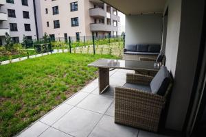 a patio with a table and chairs and a field of grass at AH Designe in Košice