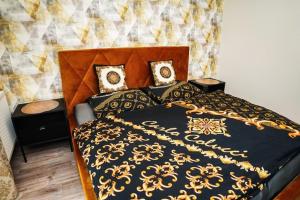 a bed with a black and gold blanket and pillows at AH Designe in Košice
