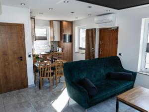 a living room with a green couch and a table at Domki MEGALO in Władysławowo