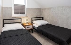 2 camas individuales en una habitación con ventana en Domki MEGALO en Władysławowo