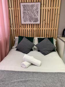 Una cama con dos almohadas y un calcetín en ella en Cambridge Suites en Harmondsworth