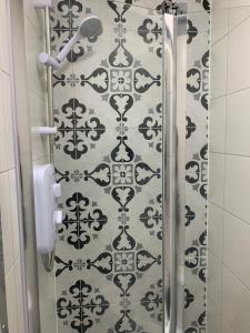 a shower in a bathroom with a black and white wallpaper at Cambridge Suites in Harmondsworth