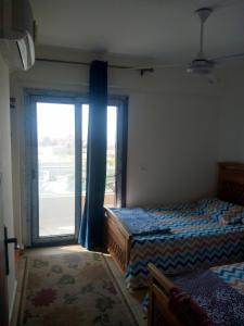een slaapkamer met 2 bedden en een groot raam bij Grand hills elsahel elshamaly in Alexandrië