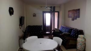 een woonkamer met een witte tafel en een bank bij Grand hills elsahel elshamaly in Alexandrië