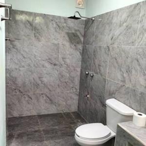 a bathroom with a toilet and a marble wall at Loft by Yuum Kiin Bacalar in Rancho Bacalar