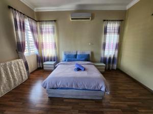 a bedroom with a bed with a blue pillow on it at Wakaf Bharu Garden Stay Semi-D By UJ in Kota Bharu