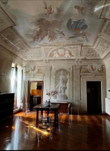 une chambre avec une table et un tableau au plafond dans l'établissement appartamento Il Magnifico, à Collesalvetti