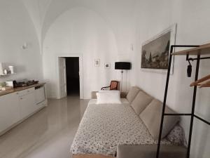 een witte woonkamer met een bank en een tafel bij La Piazza in San Giorgio Ionico