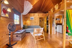una sala de estar con un sofá azul en una cabaña de madera en Cabana - Finca Lliber, en Lliber