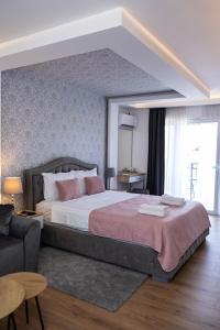 sypialnia z dużym łóżkiem i kanapą w obiekcie Marino Lux Prenoćište w mieście Požarevac