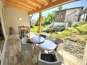 a patio with two tables and chairs on a porch at WATERFRONT - Urbane Eleganz am Bachufer in Villach