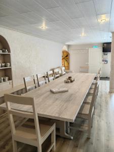 uma sala de jantar com uma grande mesa de madeira e cadeiras em Route House 39 Motel em Jõgeva