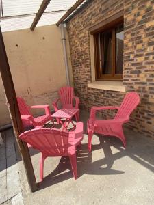 een groep roze stoelen en tafels op een patio bij Le Saint Ju' in Friville-Escarbotin