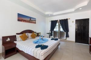 a bedroom with a bed with blue robes on it at Grand View in Patong Beach