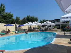 uma grande piscina azul com guarda-sóis e mesas em ElGringo Clisura Dunarii em Moldova Nouă