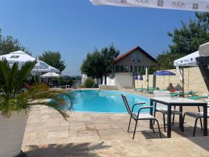 uma piscina com mesa e cadeiras ao lado em ElGringo Clisura Dunarii em Moldova Nouă