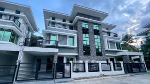 a white building with a black fence in front of it at New Cozy 3 Bedroom House in Davao City