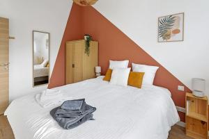 ein Schlafzimmer mit einem großen weißen Bett mit einem orangefarbenen Kopfteil in der Unterkunft L'Annexe - Maison cosy au calme avec jardin in Gorges