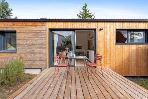 eine Holzterrasse mit einem Tisch und Stühlen darauf in der Unterkunft L'Annexe - Maison cosy au calme avec jardin in Gorges