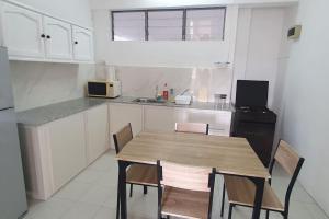 a kitchen with a wooden table and chairs in it at Appartment in town in Curepipe