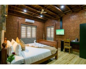 Schlafzimmer mit einem Bett und einem Schreibtisch in der Unterkunft Wayanad Fort Resort, Noolpuzha, Kerala in Muthanga