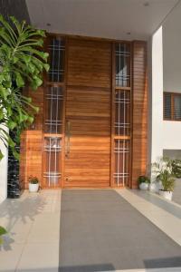 a wooden door of a building with plants at Earth - Luxurious 5 BHK AC Villa at Mysore in Mysore