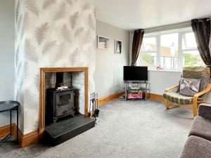 a living room with a fireplace and a tv at The Yorkshire Hosts - Spokey Dokey House in Whixley