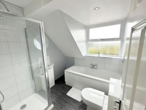 a white bathroom with a shower and a toilet at The Yorkshire Hosts - Spokey Dokey House in Whixley