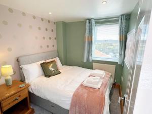 a small bedroom with a bed and a window at The Yorkshire Hosts - Spokey Dokey House in Whixley