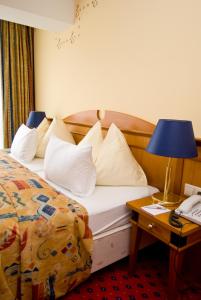 a hotel room with a bed and a table with a lamp at Thermal Resort Hotel Elisabethpark in Bad Gastein
