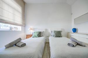 two twin beds in a room with a window at Luxury home with sea views in St. Julianʼs +52 photos
