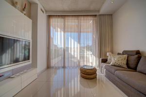 a living room with a couch and a television at Luxury home with sea views in St. Julianʼs