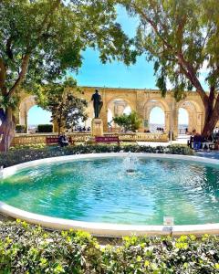 a fountain in a park with a statue in the background at Luxury home with sea views in St. Julianʼs