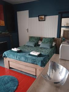 een slaapkamer met twee bedden met blauwe muren en een tafel bij Marie-Claire la grillade in Briare