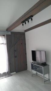 een woonkamer met een flatscreen-tv aan de muur bij Wohnung Nr 4 in Bargischow