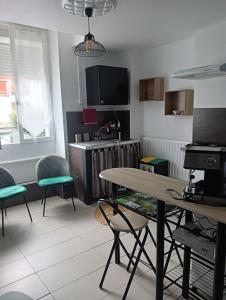een woonkamer met een tafel en stoelen en een keuken bij Marie-Claire la grillade in Briare