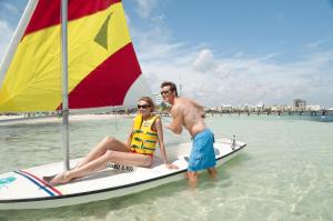 a man and a woman on a sailboat in the ocean at The Villas at The Royal Cancun - All Suites Resort in Cancún