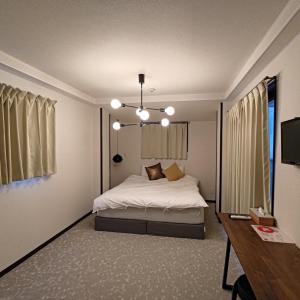 um quarto com uma cama e uma mesa em 楓ホテル402 em Osaka