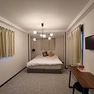 um quarto com uma cama e uma secretária. em 楓ホテル402 em Osaka