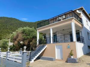 クリッシ・アモウディアにあるLa Casa de Fokas - Beach Homeのバルコニー付きの家、階段あり