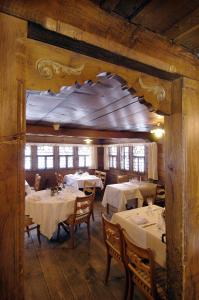 a dining room with tables with white tablecloths at Landgasthof Ruedihus in Kandersteg